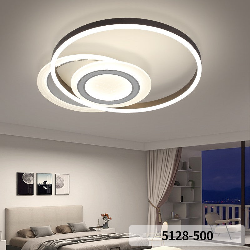 Plafoniera LED cu inele asimetrice montata in dormitor modern, lumina neutra uniforma
