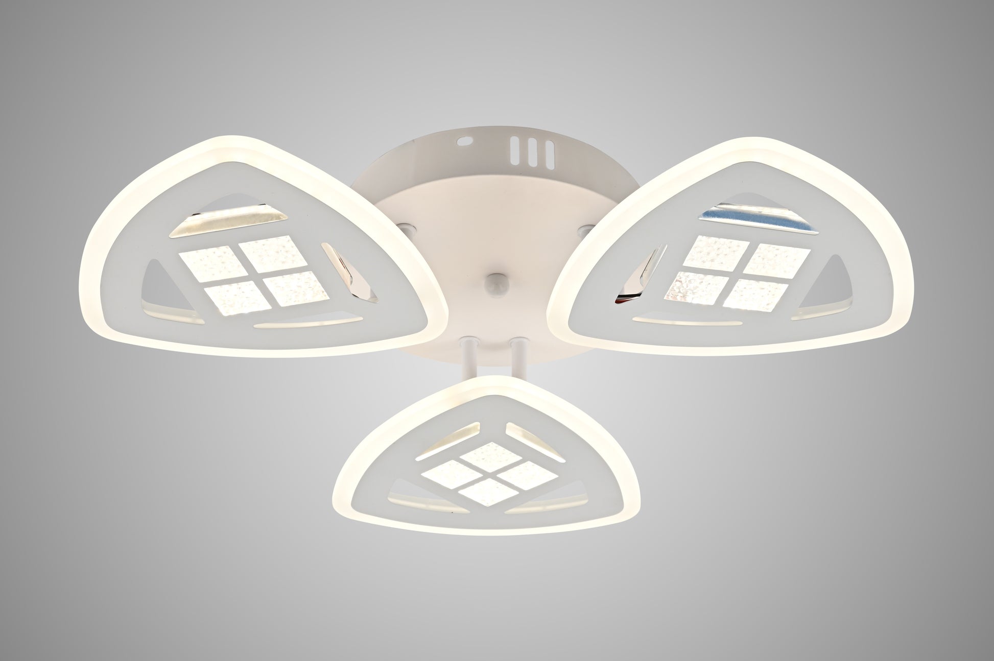 Lustra LED plafon cu 3 brate triunghiulare albe, aprinsa, vedere frontala pe fond gri