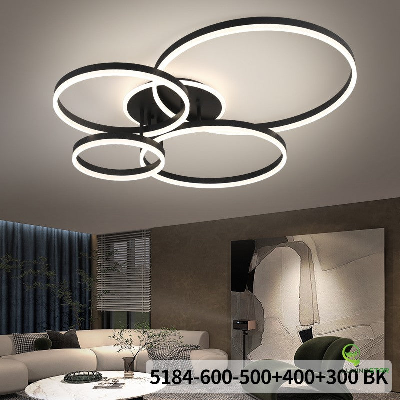 Lustra LED cu 4 inele negre instalata in living modern, lumina neutra, intensitate reglabila