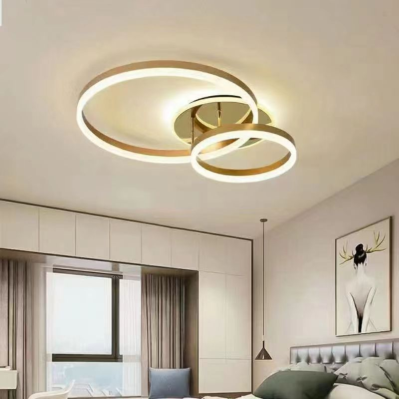 Plafoniera LED 120W cu 2 cercuri concentrice aurii, montata pe tavan in dormitor modern
