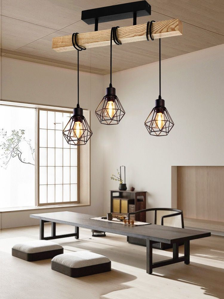Lustra cu bara din lemn rustic si 3 pendule colivie negre, montata deasupra mesei intr-un living modern