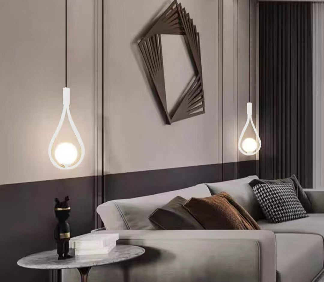 Lustra pe cablu forma picatura, soclu E14, finisaj alb mat, montata in living modern deasupra canapelei