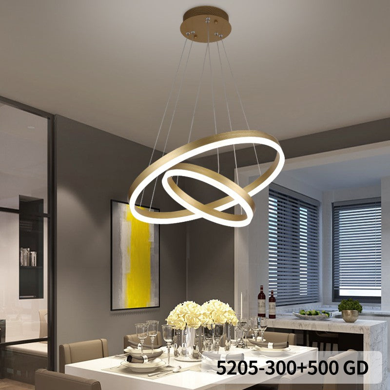 Lustra LED tip inel dublu auriu, suspendata deasupra unei mese de bucatarie, lumina calda uniforma