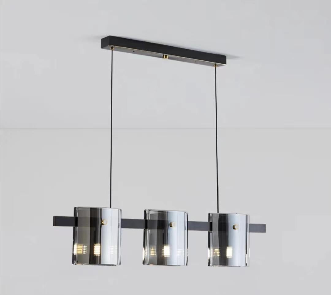 Lustra suspendata cu 3 abajururi cilindrice din sticla fumata, structura neagra mata, soclu G9, bara 800 mm
