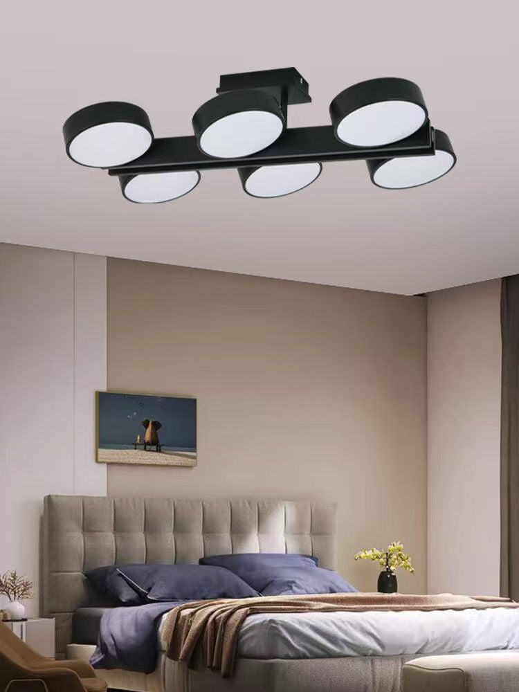 Plafoniera LED neagra cu 6 capete rotunde, instalata pe tavan in dormitor modern