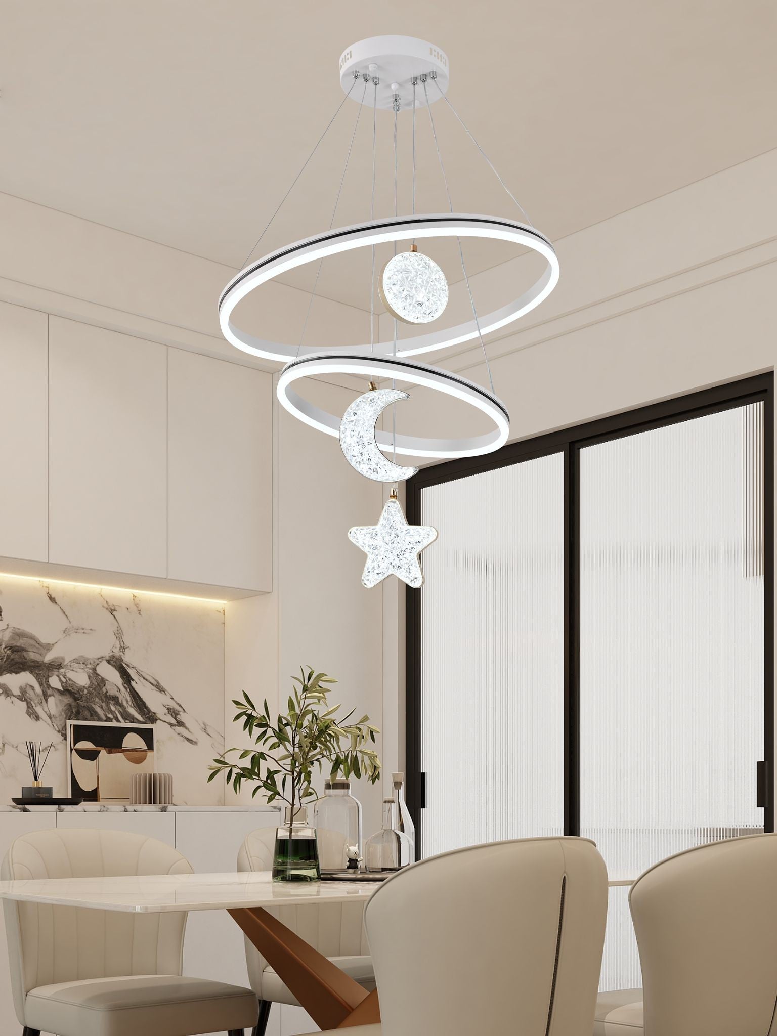 Lustra LED cu doua inele si pandantive cristaline luna si stea, montata in sufragerie moderna luminoasa