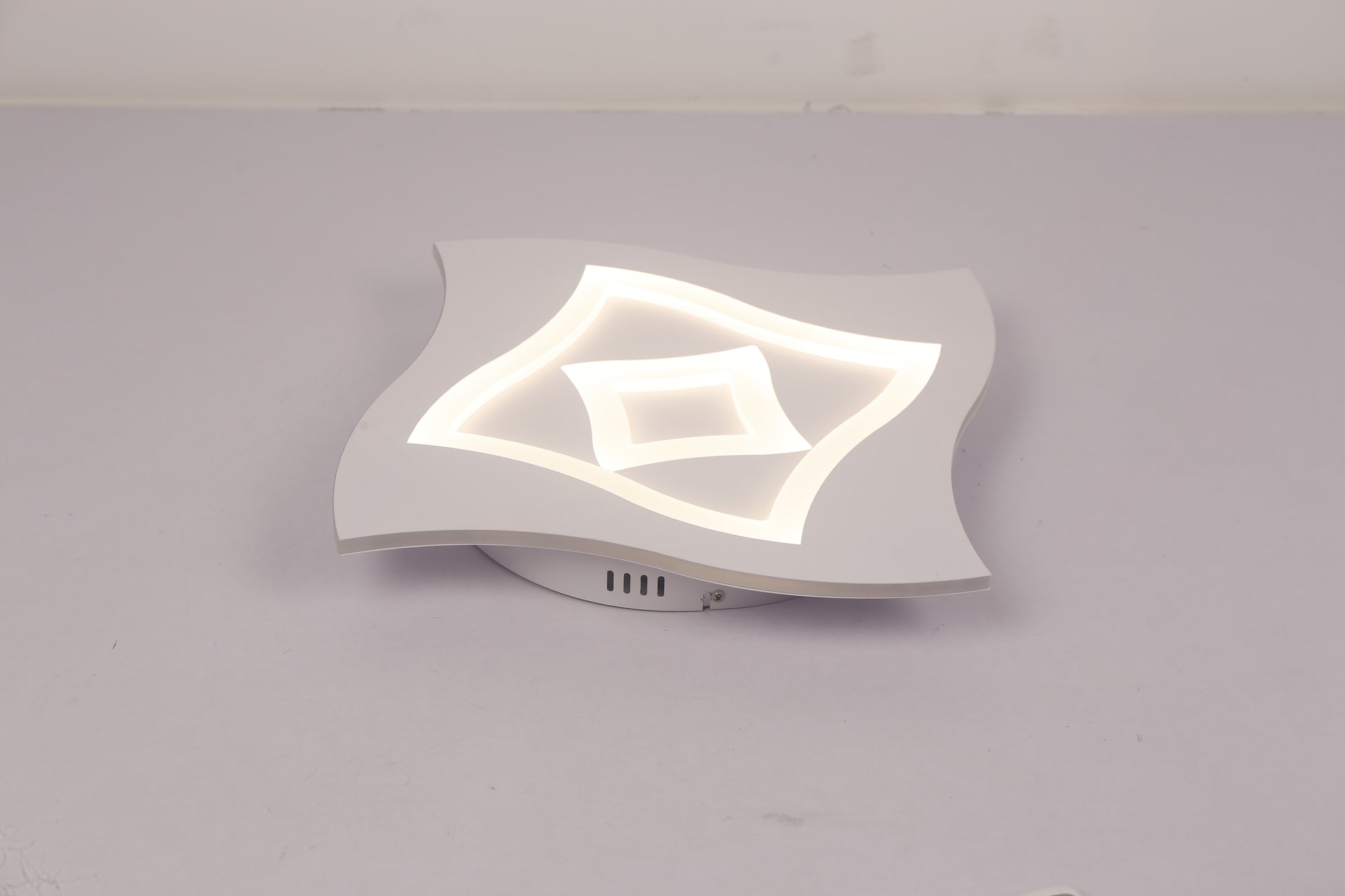 Plafoniera LED cu temperatura neutra 4000K, forma ondulata din acril, vedere laterala pe fond gri